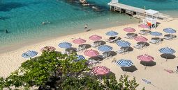 Striped umbrellas on the beach at S Hotel Montego Bay.