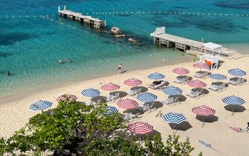 Striped umbrellas on the beach at S Hotel Montego Bay.