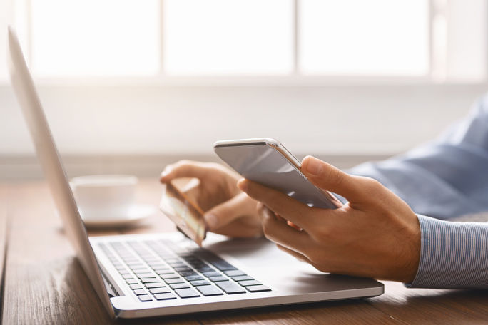 A man booking travel online. Adobe Stock, online, booking travel, credit card, fees, purchase, pricing, computer, laptop