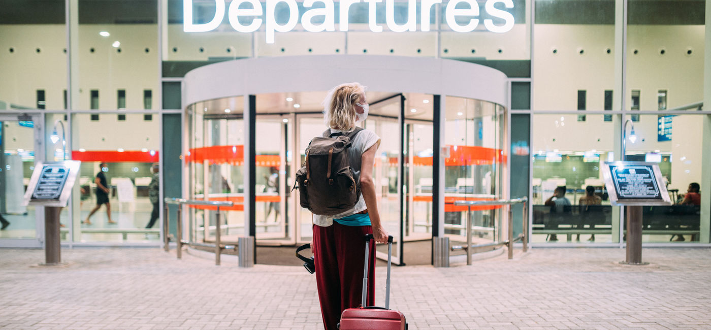 Image: Young woman heading toward her departure gate at the airport. (photo via iStock/Getty Images E+/Pyrosky)
