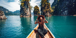 happy young woman tourist in asian hat on the boat at lake