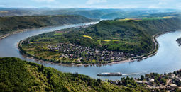 A Uniworld Boutique River Cruises ship sails around a bend in the Rhine River near Boppard, Germany.