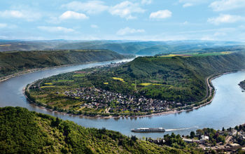 A Uniworld Boutique River Cruises ship sails around a bend in the Rhine River near Boppard, Germany.