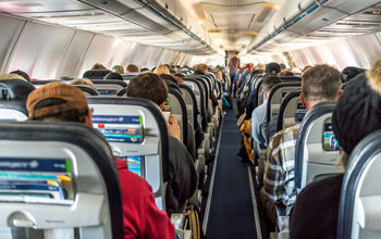 Passengers seated inside of a commercial passenger airplane.