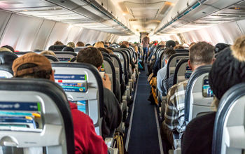 Passengers seated inside of a commercial passenger airplane.