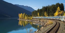 VIA Rail train glides by a lake in the Canadian Rockies_Fesh Tracks Canada