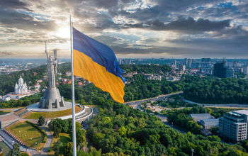 Ukrainian flag waving in the wind against the city of Kyiv, Ukraine