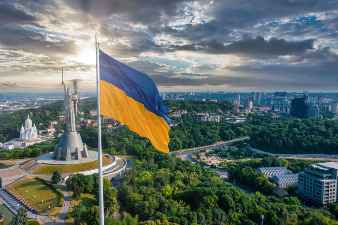 Ukrainian flag waving in the wind against the city of Kyiv, Ukraine