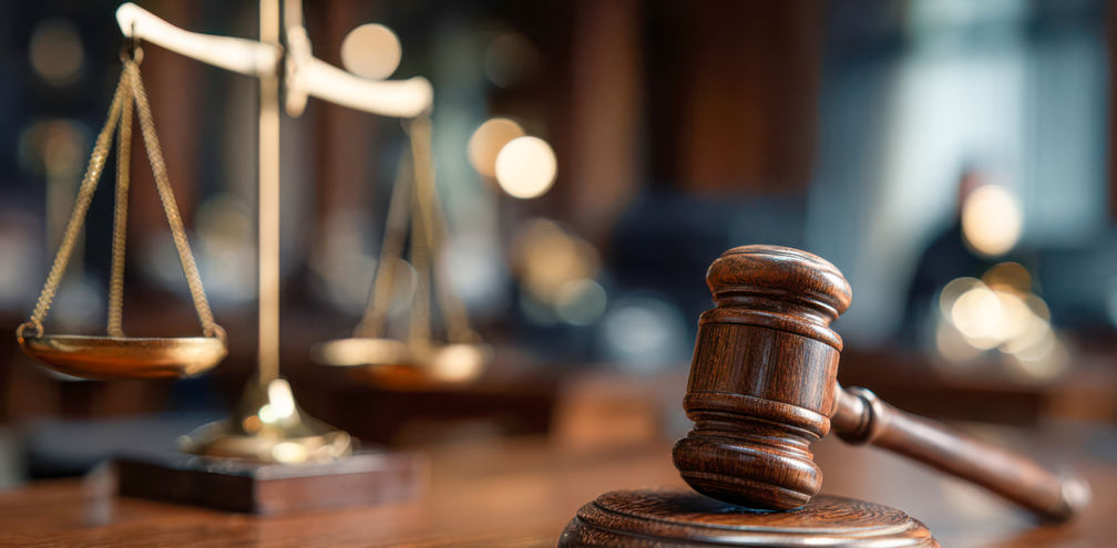 Gavel and scales displayed in a courtroom during legal proceedings