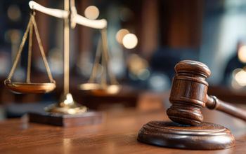 Gavel and scales displayed in a courtroom during legal proceedings