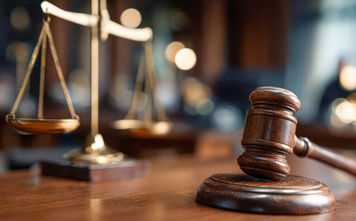 Gavel and scales displayed in a courtroom during legal proceedings