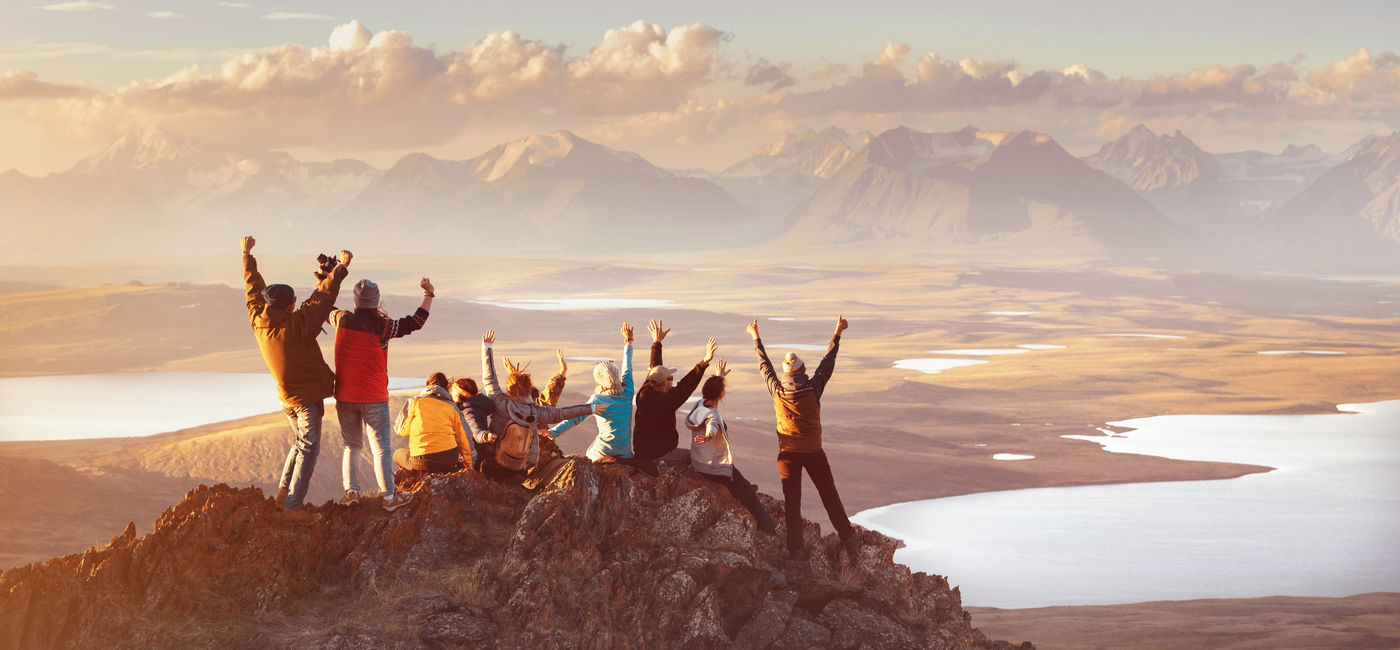 Image: Large group of friends in mountains area. (Photo Credit: cppzone / Adobe Stock)