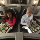 Male and female passenger dining Alaska Airlines international suites