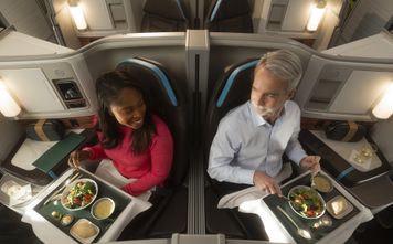 Male and female passenger dining Alaska Airlines international suites