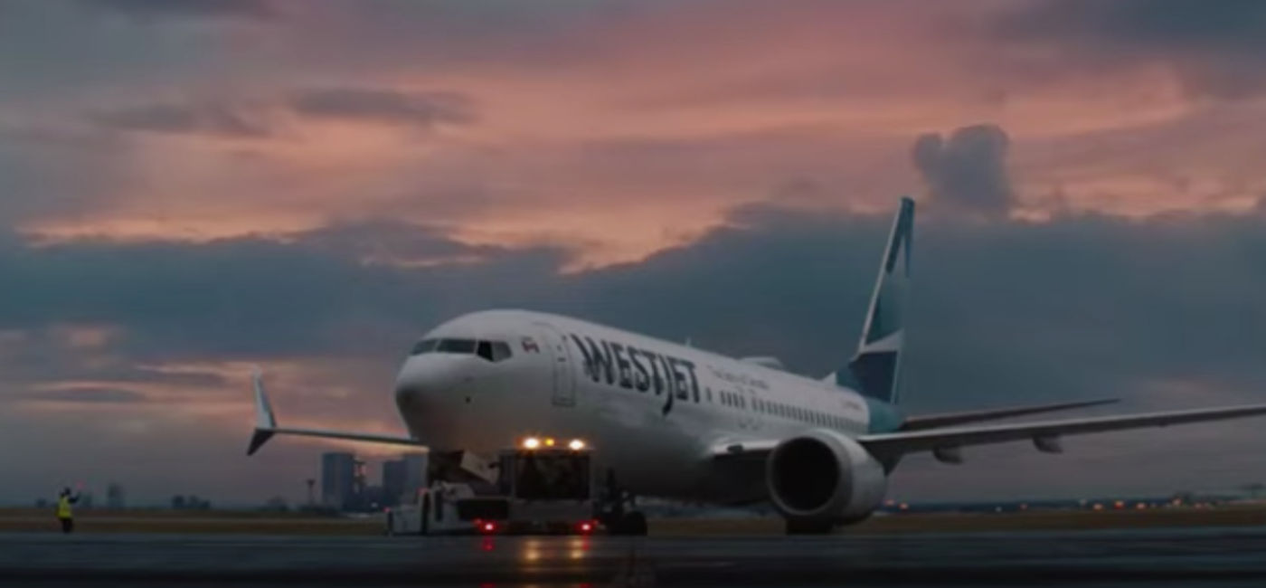Image: Guests surprised in-flight with opportunity to give back $1 for every mile flown to their favourite charities. (Photo Credit: WestJet)