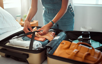 Woman packing a suitcase, suitcase, packing, packing for vacation, packing a suitcase