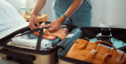 Woman packing a suitcase, suitcase, packing, packing for vacation, packing a suitcase