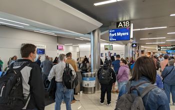 Airport crowd gathers at gate to board flight