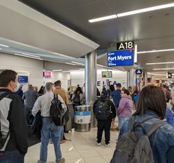 Airport crowd gathers at gate to board flight