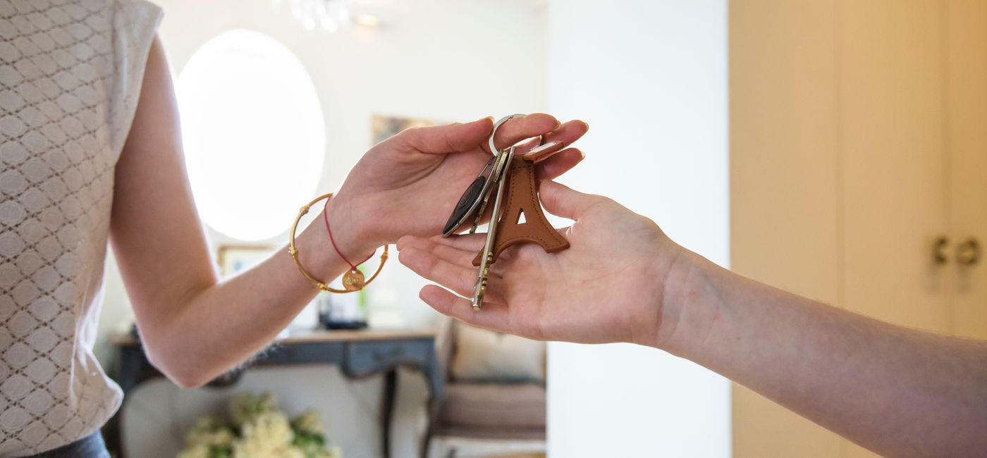 Image: Vacation rental host handing keys to a guest. (Photo Credit: Adobe Stock/Julien)
