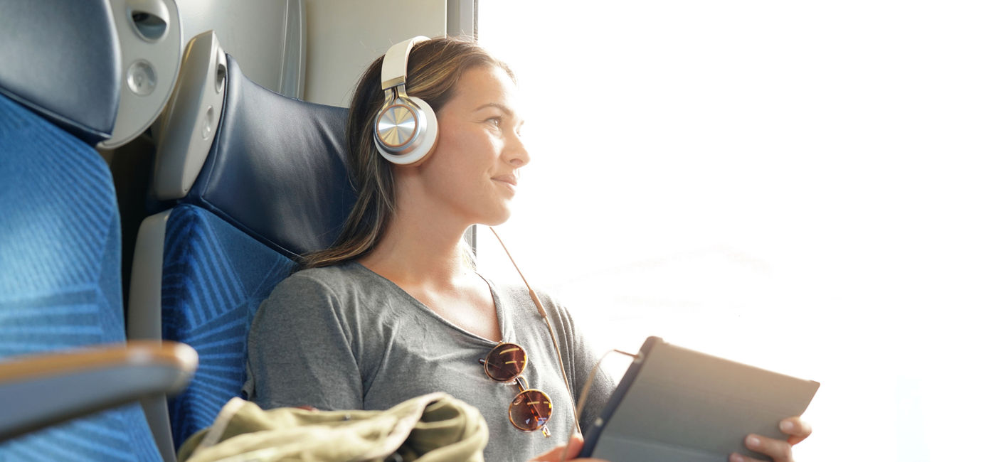 Image: Woman traveling by train. (Photo Credit: goodluz/Adobe)
