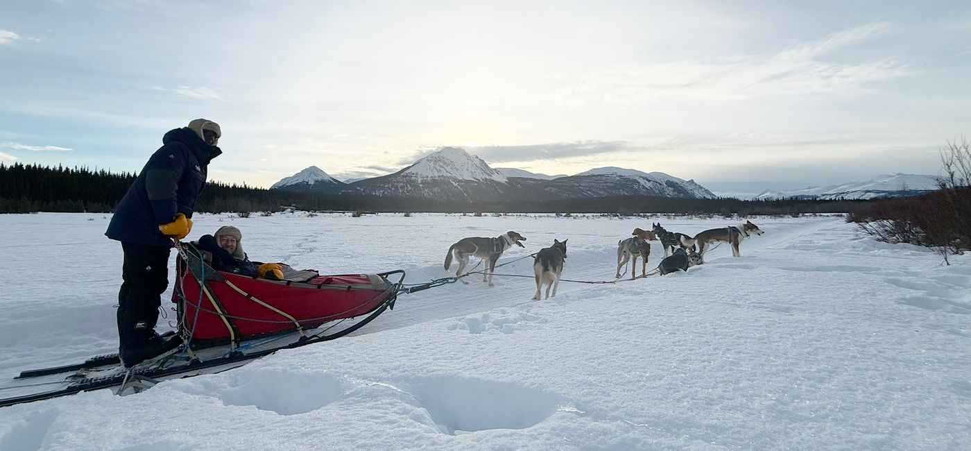Image: The author (seated) and his husband try out dogsledding at the Southern Lakes Resort in Canada's Yukon Territory. (Photo Credit: Photo by Paul J. Heney.)