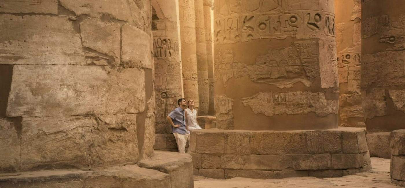 Image: A couple peruses giant columns in Egypt. (Photo Credit: Egyptian Tourism Authority)