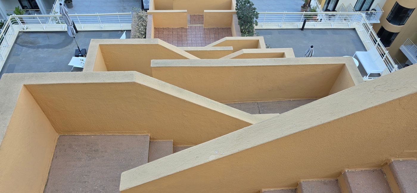 Image: Un des escaliers extérieurs fantaisistes qui relient deux niveaux de cour (Photo Credit: Bert Archer)