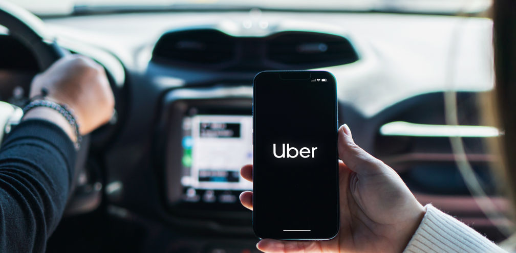 Car passenger using the Uber app on her mobile phone.