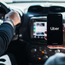 Car passenger using the Uber app on her mobile phone.
