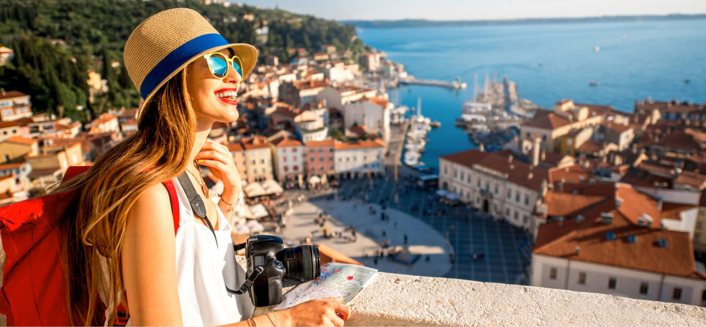 Image: A young female traveler exploring old town Piran, Slovenia. (Photo Credit: Adobe Stock/rh2010)