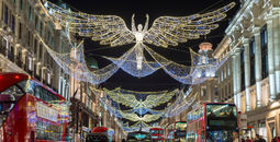 Double-decker buses pass beneath Christmas lights on Regent Street, London, U.K.