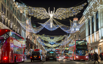 Double-decker buses pass beneath Christmas lights on Regent Street, London, U.K.