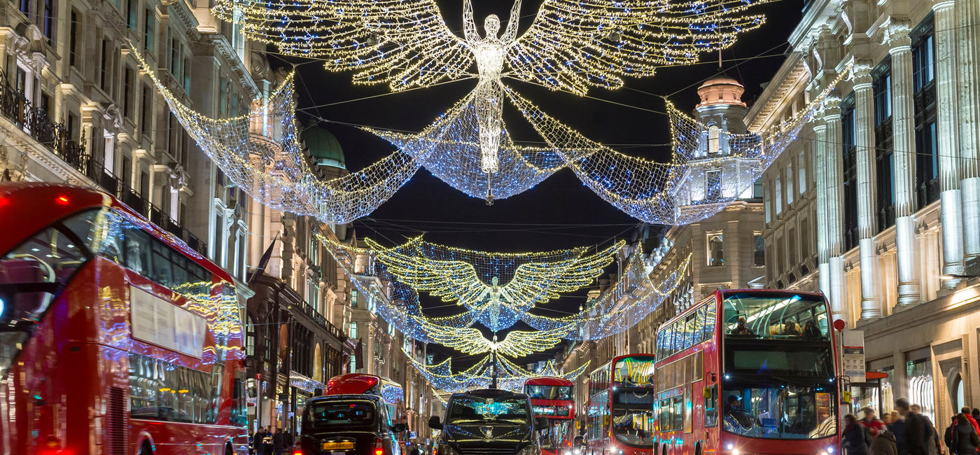 Image: Double-decker buses pass beneath Christmas lights on Regent Street, London, U.K. (Photo Credit: Adobe Stock/lazyllama)