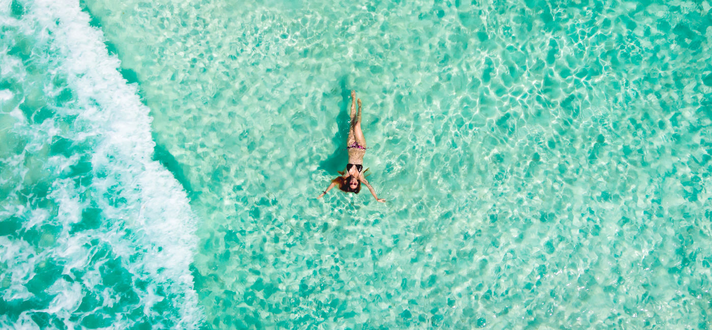 Image: Woman floating in the Caribbean Sea in Cancun, Mexico. (Photo Credit: Andrea/Adobe)