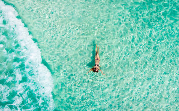 Woman floating in the Caribbean Sea in Cancun, Mexico