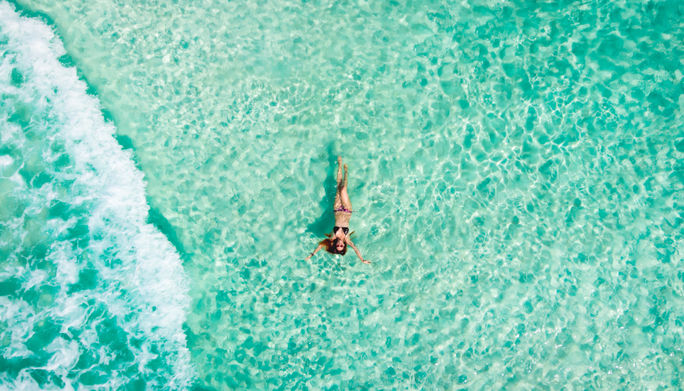 Woman floating in the Caribbean Sea in Cancun, Mexico