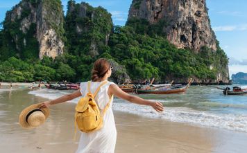 Young female traveler enjoying a summer vacation on a tropical beach in Krabi, Thailand.
