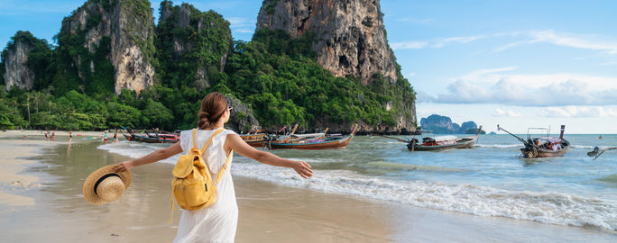 Young female traveler enjoying summer vacation on a tropical beach in Krabi, Thailand.