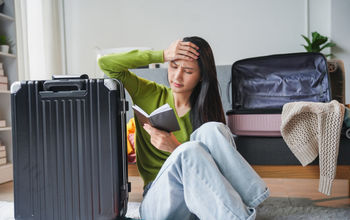 A traveler feeling stressed while packing for her trip.
