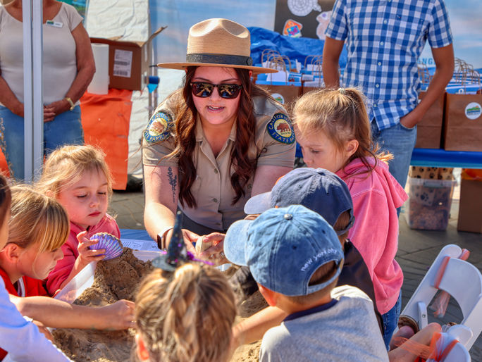 Children learning about reburying clams in Pismo Beach, California