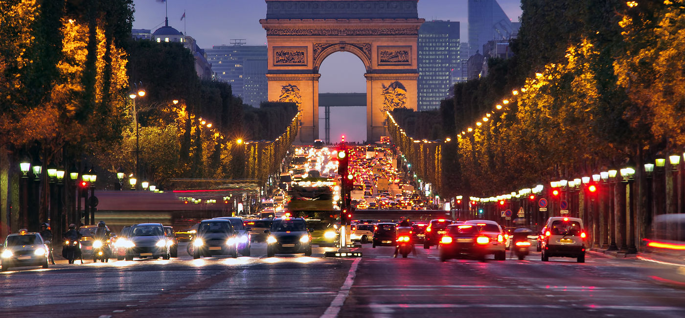 Image: The Champs Elysees and Arc de Triomphe at dusk in Paris, France. (Photo Credit: Ioan Panaite / Adobe Stock)