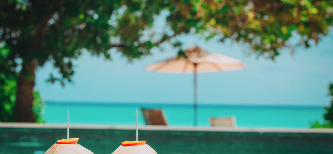 Image: Coconut drinks at a tropical beach resort. (Photo Credit: nadezhda1906 / Adobe Stock)