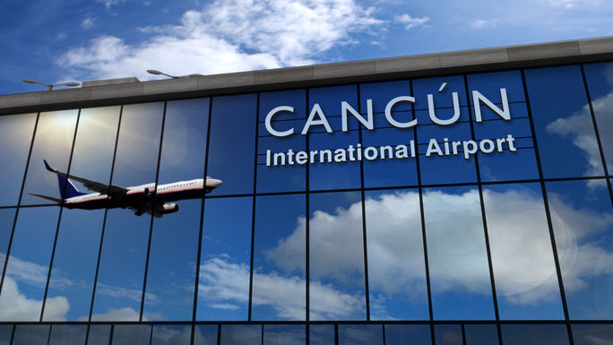 Airplane landing at Cancun International Airport.