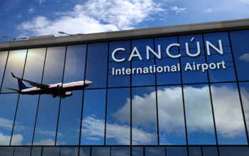 Airplane landing at Cancun International Airport.