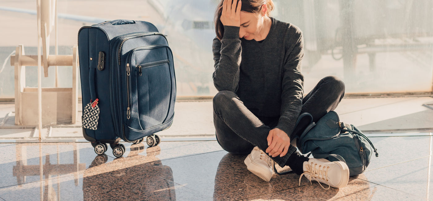 Image: Frustrated traveler waiting for flight. (Photo Credit: Alina Rosanova/Adobe)