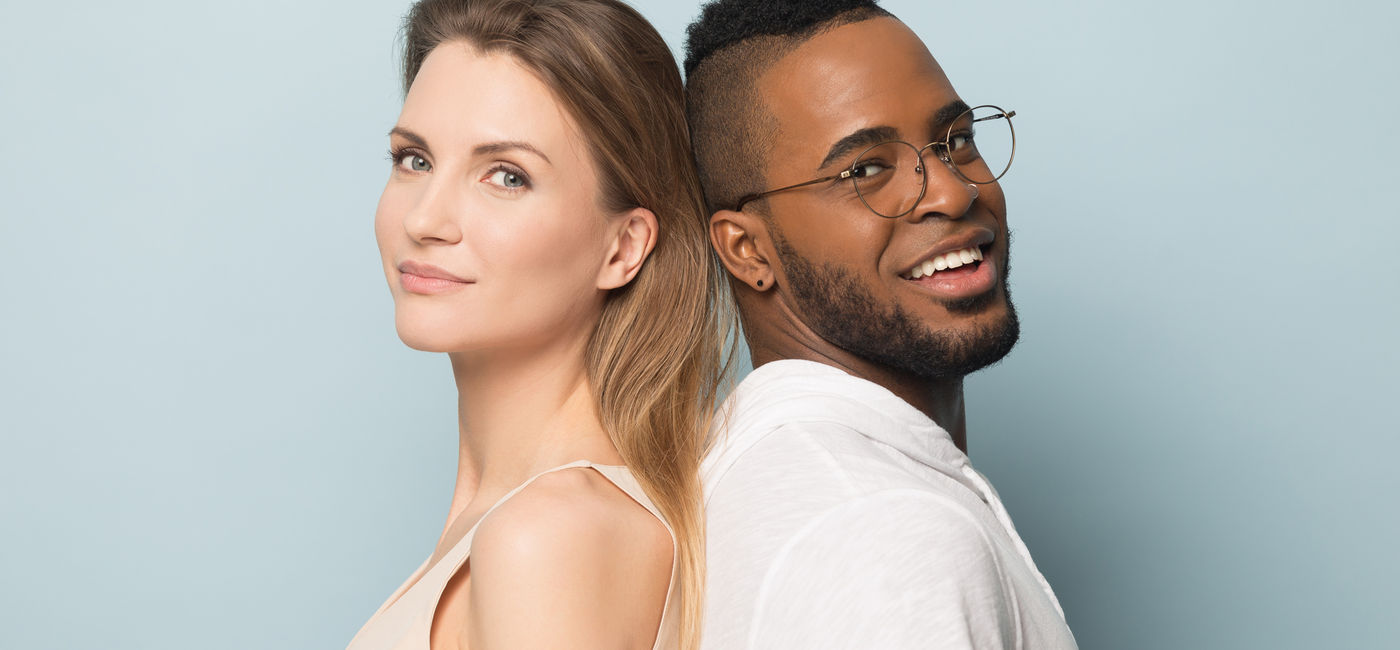 Image: Man and woman standing back-to-back. (Photo Credit: Adobe Stock/fizkes)