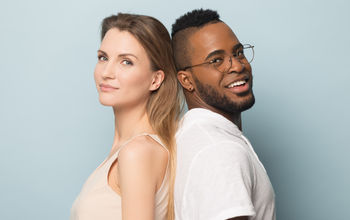 Man and woman standing back-to-back.