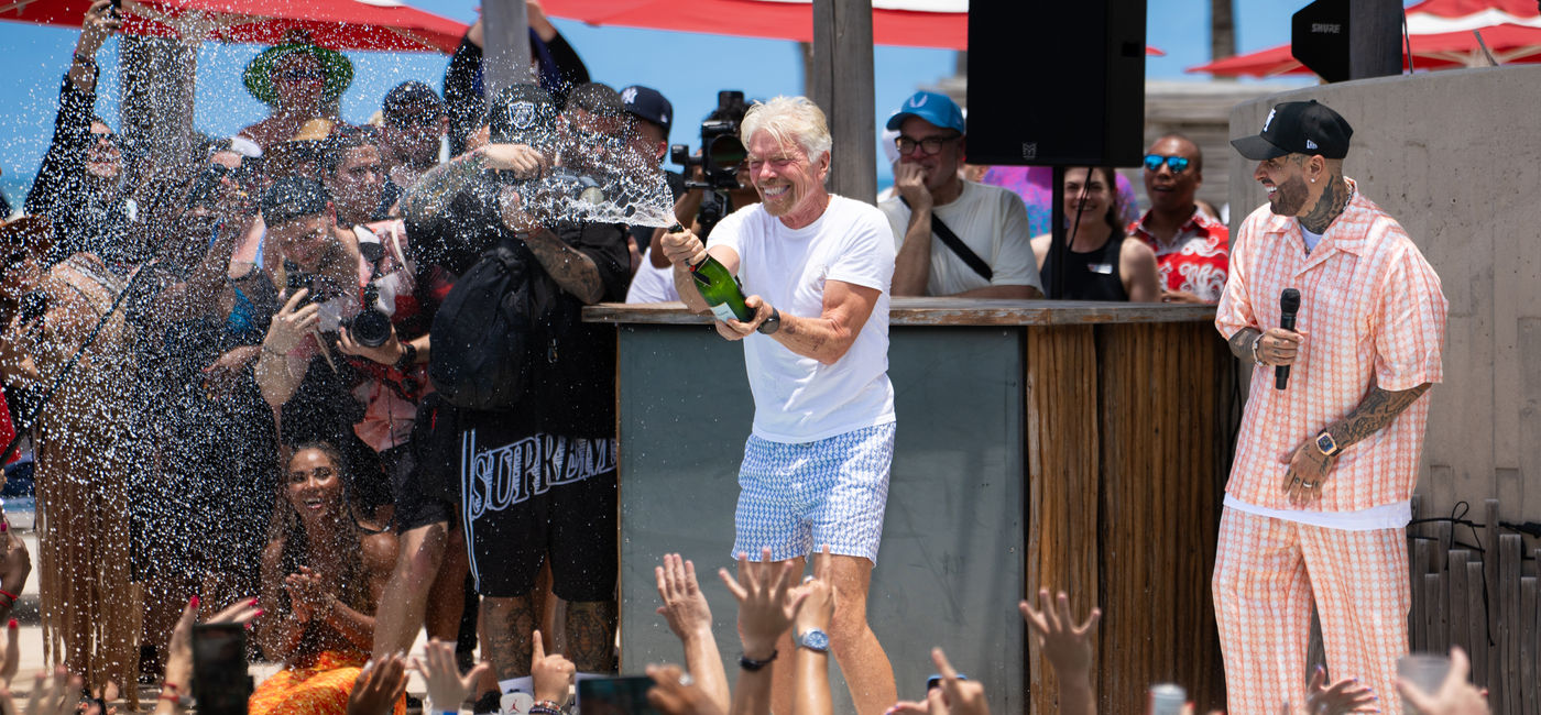 Image: Richard Branson celebrates with champagne in Bimini, Bahamas. (Photo Credit: Virgin Voyages)