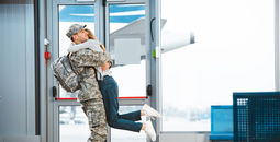 Woman greets military spouse at airport. 